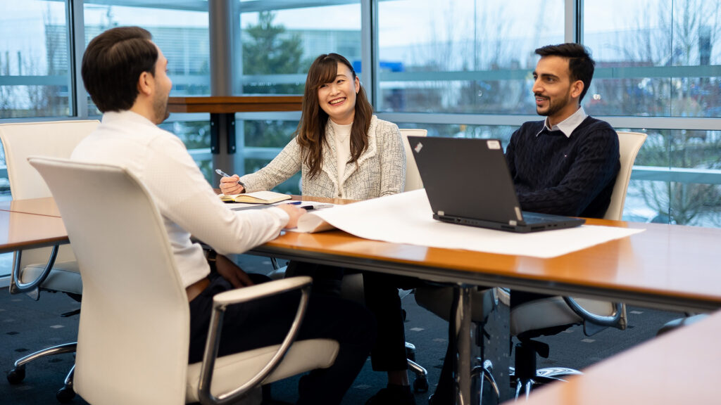 Three people from the Houle team brainstorming in the office meeting room.