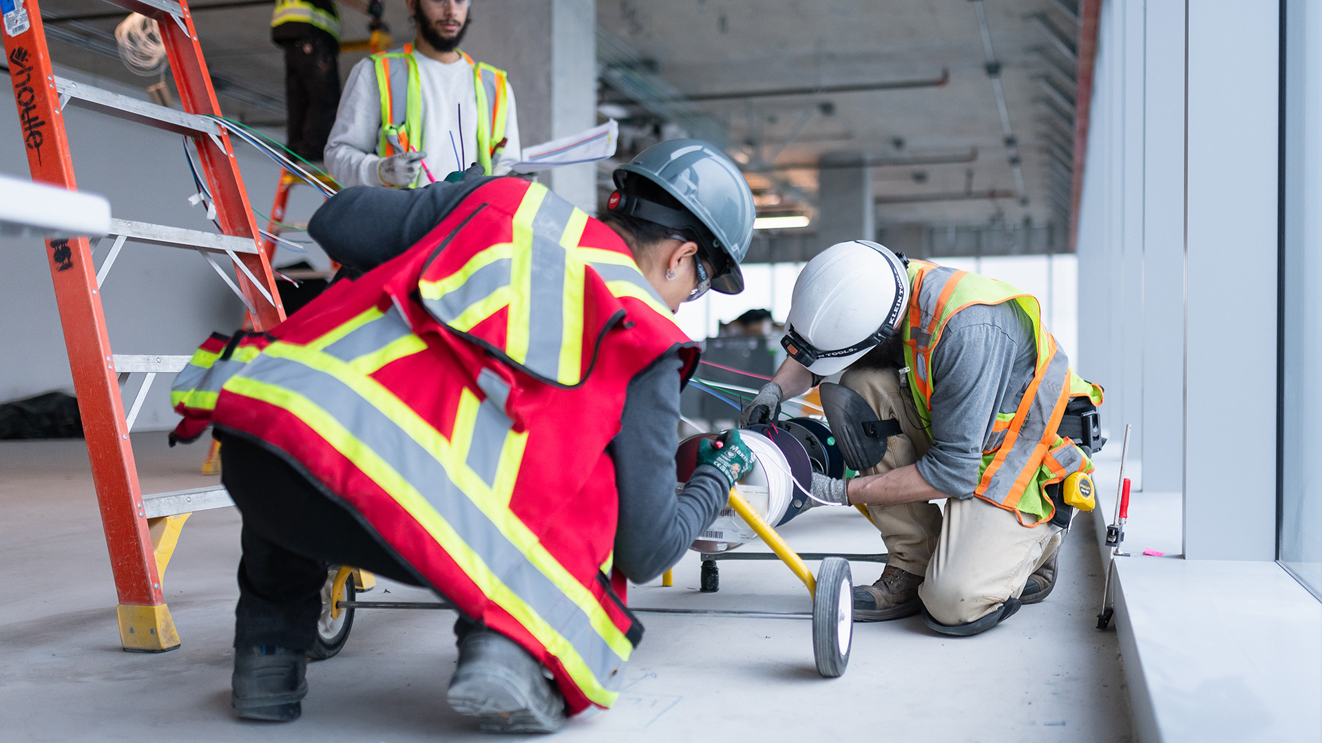 3 people from the Houle team inspecting electrical wires