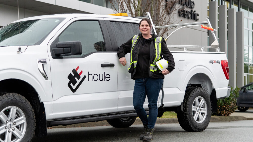 A Houle team member standing with the company vehicle.