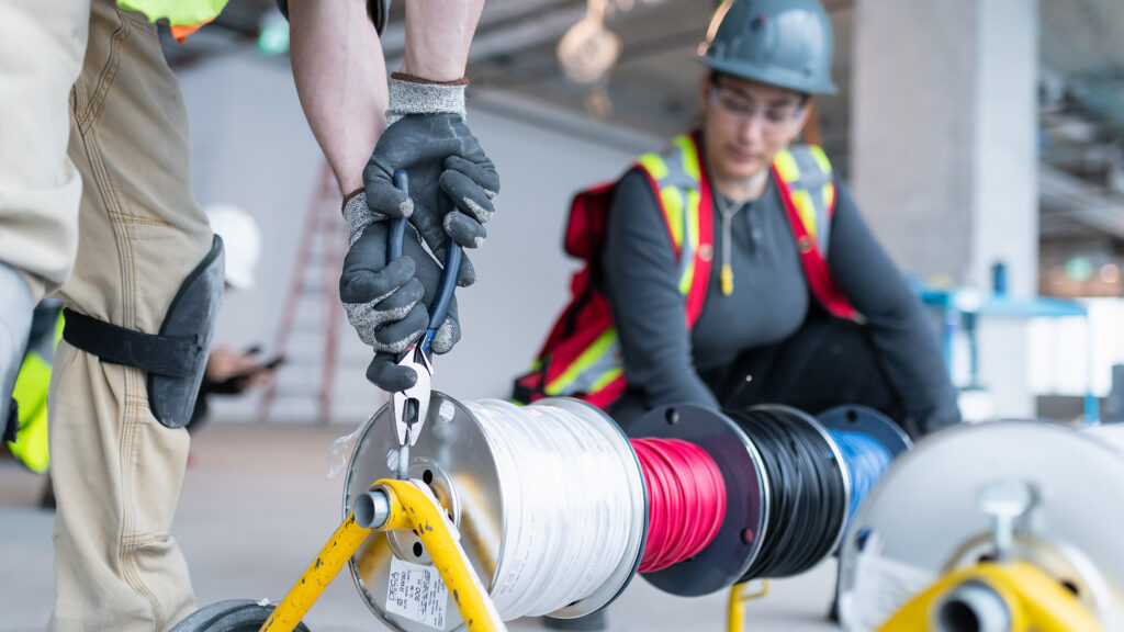 Houle employee pulling wire from the spools.