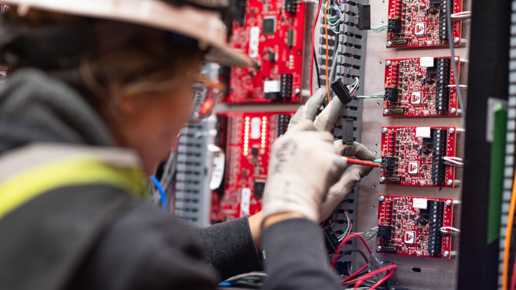 Electrician installing a security panel.