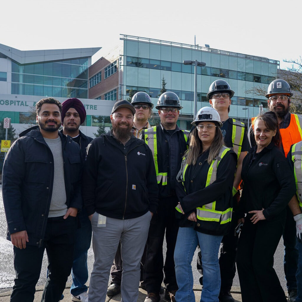 Houle Technology team taking a group photo in front of the Abbotsford Hospital and Cancer Centre