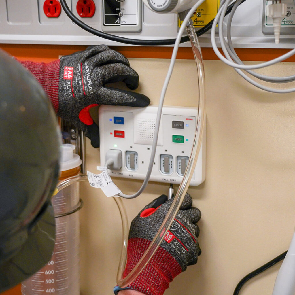A Houle Technician is installing a Nurse Call Wall Device